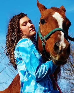 A photo of Carley Dole, a spinal cord injury survivor and TBI survivor, shares her insights in a blog post for Spinal Cord. The photo features her with a horse.