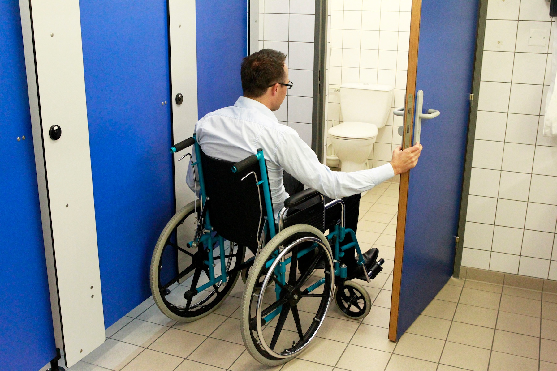 Male in wheelchair in restroom with bowel and bladder issues due to a spinal cord injury