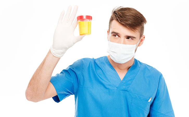 man holding urine sample for UTI